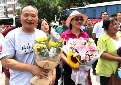 父亲手捧鲜花等孩子，愿孩子考个好成绩